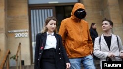 Українець, який подав позов до суду Аргентини щодо вчинених проти нього тортур з боку росіян, разом із юристкою Оксфордського університету Цветеліною ван Бентем та співзасновницею The Reckoning Project Наталею Гуменюк. Буенос-Айрес, 15 квітня 2024. REUTERS/Agustin Marcarian
