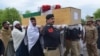 Relatives and security officials carry a coffin of one of the policeman who was killed by a roadside bomb in Lakki Marwat district of Khyber Pakhtunkhwa province on March 30, 2023.