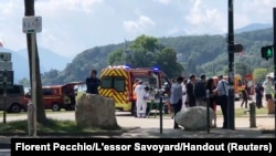 Medics and emergency personnel work at the site where a person wounded four children and an adult in a knife attack in a park in Annecy, France, June 8, 2023.