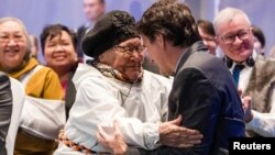 Canada’s Prime Minister Justin Trudeau, right, is greeted by an elder during a devolution ceremony at the Aqsarniit Hotel & Conference Centre in Iqaluit, Nunavut, Canada, Jan. 18, 2024.