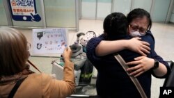 资料照片：2023年3月14日，北京首都国际机场一名女子等到了乘坐国际航班抵达北京的亲人。（美联社照片）