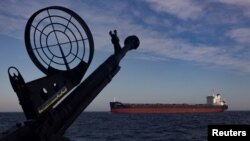 Вантажний корабель проходить поблизу патрульного катера морської охорони України в Чорному морі, 7 лютого 2024 року. Фото: Reuters/Thomas Peter