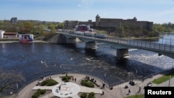 Пункт пропуску на кордоні Естонії та Росії розташований на мості через ріку Нарва. На фото: новозбудований у російському місті Івангород екран із трансляцією параду на Красній площі до 9 травня, розвернутий на сторону естонського міста Нарва. 9 травня 2023. REUTERS/Janis Laizans