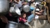 FILE - Palestinians line up for free food during the ongoing Israeli air and ground offensive on the Gaza Strip in Rafah, Jan. 9, 2024.