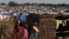 FILE - Sudanese women, who fled the conflict in Geneina in Sudan's Darfur region, walk beside makeshift shelters in Adre, Chad, Aug. 5, 2023. 