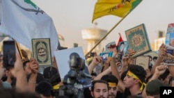 Iraqis raise copies of the Quran, Muslims' holy book, during a protest in Tahrir Square, July 20, 2023 in Baghdad, Iraq. 