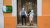 FILE - An elderly couple arrives at a polling station to vote, in Rome, Italy, Sept. 25, 2022. 