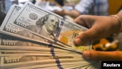 Un empleado muestra billetes en dólares estadounidenses en un cambiador de dinero en Yakarta, Indonesia, el 24 de abril de 2018. Fotografías tomadas el 24 de abril de 2018.
