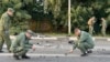 In this handout photo taken from video released by Investigative Committee of Russia on Sunday, Aug. 21, 2022, investigators work on the site of explosion of a car driven by Daria Dugina outside Moscow. (Investigative Committee of Russia via AP)