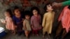 FILE - A health worker administers a polio vaccine to a child in Lahore, Pakistan, Feb. 28, 2022, as other children line up.