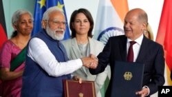 জার্মানির বার্লিনে চ্যান্সেলারিতে অনুষ্ঠিত বৈঠকের অংশ হিসেবে, এক চুক্তিস্বাক্ষর অনুষ্ঠানের পর হাত মেলাচ্ছেন জার্মাসির চ্যান্সেলর ওলাফ শোলজ (ডানে) এবং ভারতের প্রধানমন্ত্রী নরেন্দ্র মোদী (বামে), ২ মে ২০২২।
