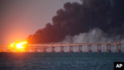 Flame and smoke rise from the Crimean bridge connecting the Russian mainland and the Crimean peninsula over the Kerch Strait, in Kerch, Crimea, Oct. 8, 2022. 