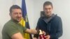 Владимир Зеленский, слева, вручает медаль мэру южного города Мелитополь Ивану Федорову, который находился в плену у российских войск.