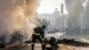 A firefighter helps a colleague escape a crater after a Russian attack in Kyiv, Ukraine, Oct. 10, 2022. Russia unleashed a lethal barrage of strikes on Monday, destroying civilian targets in several Ukrainian cities. The attack on Kyiv left cars burned, w