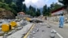 FILE - Local residents walk in the road destroyed by floodwaters in Kalam Valley in northern Pakistan, Sept. 4, 2022.