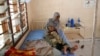 FILE - A Somali refugee holds a toddler at a hospital in the Dadaab refugee camp, Kenya, Dec. 19, 2017. Doctors Without Borders warned Oct. 27, 2022, of possible measles and cholera outbreaks in the camp as refugees arrive from Somalia, where the diseases are circulating.