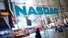 ARCHIVO - Un transeúnte para frente a un cartel que anuncia el índice tecnológico Nasdaq en Times Square, Nueva York, en junio de 2012.