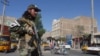 A Taliban fighter stands guard on a road after a blast during Friday prayers at Guzargah mosque, in Herat, Sept. 2, 2022.