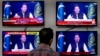 A man watches news channels broadcast a live address to the nation by Pakistan's Prime Minister Imran Khan, in Islamabad, Pakistan, March 31, 2022. 
