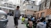 资料照：一名中国男子看着上海一座清真寺的维吾尔穆斯林祈祷。(2014年4月11日)