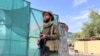 FILE - A Taliban fighter stands guard near the site where al-Qaida leader Ayman al-Zawahiri was killed in a U.S. strike over the weekend, in Kabul, Afghanistan, Aug. 2, 2022. The Taliban have ordered journalists not to go near the area.