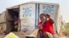 FILE - Mtonga Iliamgee, an internally displaced person at the Guma IDPs camp, prepares flour as the first meal for her family inside the camp in Benue State in north central Nigeria, Jan 6, 2022.