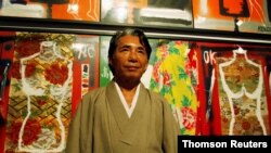ARCHIVO - El diseñador japonés Kenzo Takada posa para la prensa frente a sus diseños en una galería de arte en Buenos Aires, el 7 de abril de 2009.