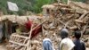 Afghan children stand near a house that was destroyed in an earthquake in the Spera district of the southwestern part of Khost Province, Afghanistan, June 22, 2022.
