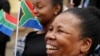 People hold South African flags as Nelson Mandela Foundation CEO Sello Hatang speaks to the press on the steps of the Johannesburg High Court, Aug. 21, 2019, after South Africa's Equality Court restricted the display of the old apartheid-era flag.