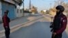 Security officials stand guard on a blocked road leading to a counter-terrorism center where several Pakistani Taliban detainees have taken police officers and others hostage inside the compound, in Bannu, a district in the Pakistan's Khyber Pakhtunkhwa province, Dec. 19, 2022. 