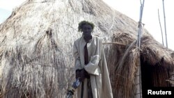 Un membre de la garde royale de Charles Wesley Mumbere est menotté après que les agences de sécurité ougandaises l'ont appréhendé avec des fusils d'assaut et des engins explosifs artisanaux lors d'une fouille dans un des sanctuaires du royaume près du village de Kasese de la RDC, 29 novembre 2016. 