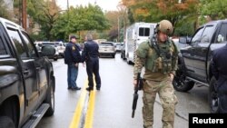 A SWAT police officer and other first responders respond after a gunman opened fire at the Tree of Life synagogue