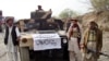 FILE - Members of Tehrik-i-Taliban Pakistan are pictured next to a captured armored vehicle in the Pakistan-Afghanistan border town of Landikotal, Nov. 10, 2008. The Pakistani Taliban have intensified attacks inside Pakistan from bases across the Afghan border in recent months.