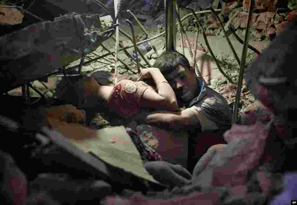 A man holds a woman after the Rana Plaza garment factory collapsed in Savar near Dhaka, killing more than 1,100 people, April 25, 2013.&nbsp;