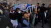 Men carry the body of priest William Siraj, who, according to police, was killed by unknown armed men in Peshawar, Pakistan, Jan. 30, 2022. 
