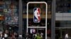 El logotipo de la NBA se muestra cuando las personas pasan por la tienda de la NBA, en Nueva York.