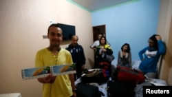 Warga Bolivia Brian Jauregui (kiri) keluarganya di dalam kamar di Hotel Opcao di Manaus, Brazil (16/6). (Reuters/Andres Stapff)