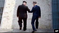 남북 정상회담이 열린 지난달 27일 김정은 북한 국무위원장과 문재인 한국 대통령이 손을 잡고 판문점 남북 경계선을 넘고 있다.