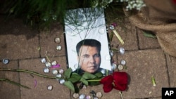 A rose lays next to an image of Muhammad Ali at a makeshift memorial at the Muhammad Ali Center, June 5, 2016, in Louisville, Kentucky. Ali, the heavyweight champion whose fast fists and irrepressible personality transcended sports and captivated the world, die