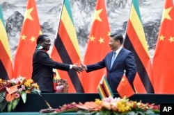 FILE - Zimbabwean President Emmerson Mnangagwa, left, shakes hands with Chinese President Xi Jinping as they pose for the media after a signing ceremony at the Great Hall of the People in Beijing, China, April 3, 2018.