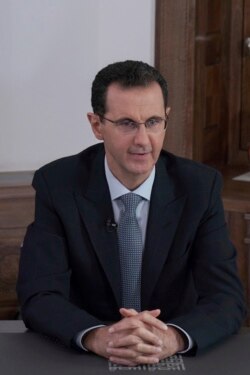 In this photo released on the official Facebook page of the Syrian Presidency, Syrian President Bashar al-Assad speaks during a televised address in Damascus , Syria, Feb. 17, 2020.