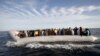 FILE - Migrants, who tried to flee to Europe, travel in a dinghy after they were stopped by Libyan coast guards and made to head to Tripoli, Sept. 29, 2015. The North African country has turned into a major hub for human traffickers smuggling African migrants by boat to Italy, with the Libyan coastguard under pressure from Europe to stem the flow. 