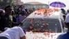 A woman cries as she leans on the hearse containing the coffin of late Suriname President Desi Bouterse during his funeral procession in downtown Paramaribo on Jan. 4, 2025. 