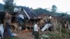 FILE - A man looks at homes destroyed by airstrikes in a refugee camp in Laiza, Myanmar, on Oct. 10, 2023. 