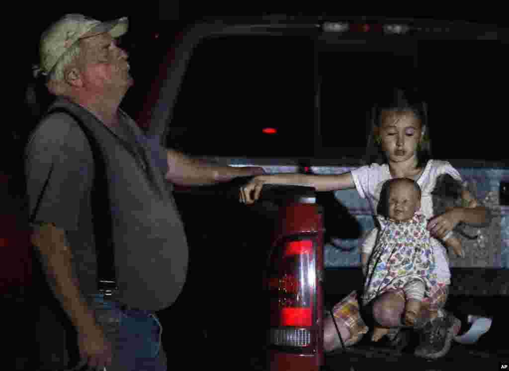 Seven-year-old Katrina Ash holds a doll as she waits in the back of a truck with her grandfather, Michael Bowen, after a tornado ripped through their neighborhood near Dale, Oklahoma, May 19, 2013.