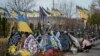 Жінка доглядає могилу загиблого в боях родича на кладовищі в Бучі, біля Києва, 30 березня 2024 р. 31 березня українці відзначають 2-у річницю визволення Бучі від російської окупації, призвела до загибелі сотень мирних жителів. (Фото: AP Photo/Enric Marti)