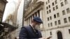 ARCHIVO - Un hombre usa una máscara protectora mientras pasa frente a la Bolsa de Valores de Nueva York, el 13 de marzo de 2020.