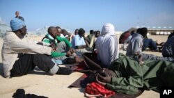 Wahamiaji wa Kiafrika wakipumzika baada ya kuokolewa nje ya mwambao wa Libya. 