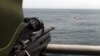 FILE - A Turkish commando, left, points his rifle toward five pirates surrounded in the Gulf of Aden, off the coast of Somalia, July 24, 2009.