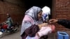 A health worker administers a polio vaccine to a child in a neighborhood of Lahore, Pakistan, Jan. 25, 2022.